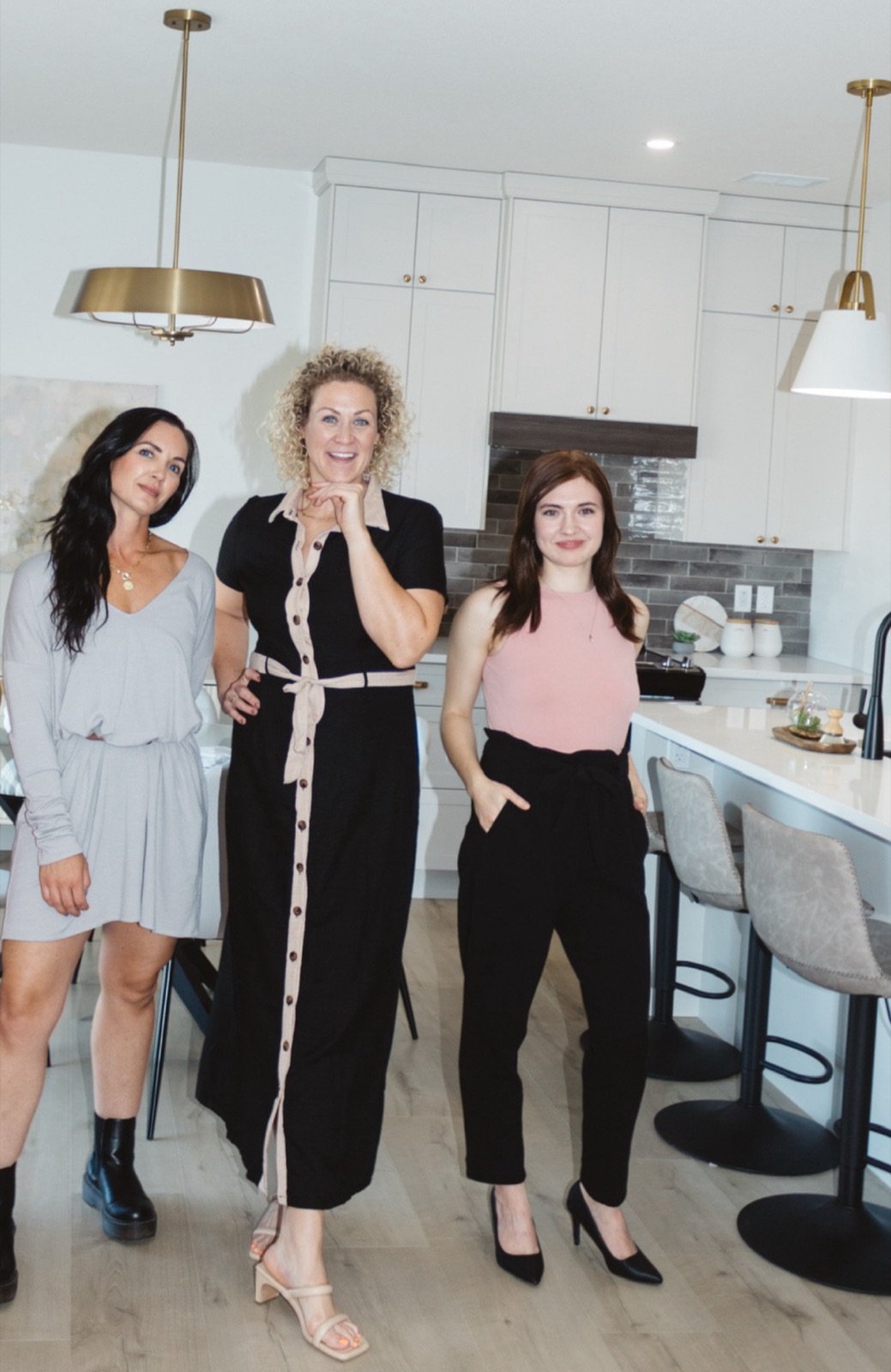 Aimée Lauren Leslie with stylists from the Aimee Lauren Interiors team in a staged white kitchen